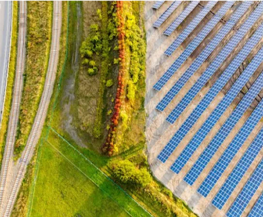Un campo verde e una strada di accesso accanto a un parco solare