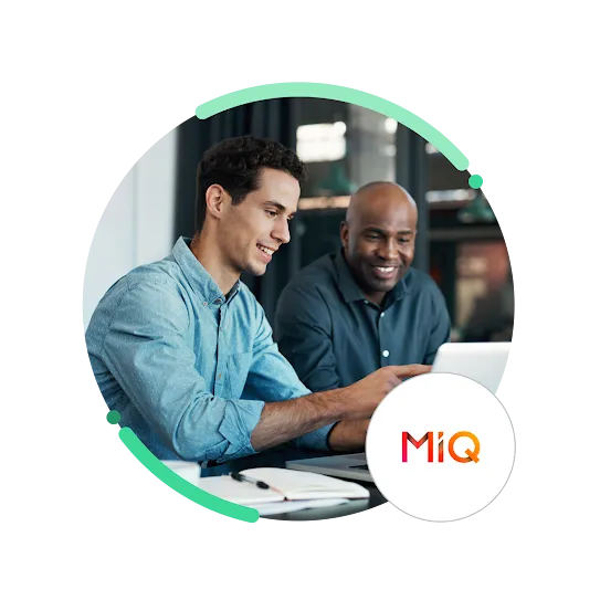 A photo of two professionals engaged in a discussion while working on a laptop, with a MiQ logo.