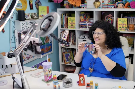 A hobbyist shows off their handiwork while live casting from their smartphone.